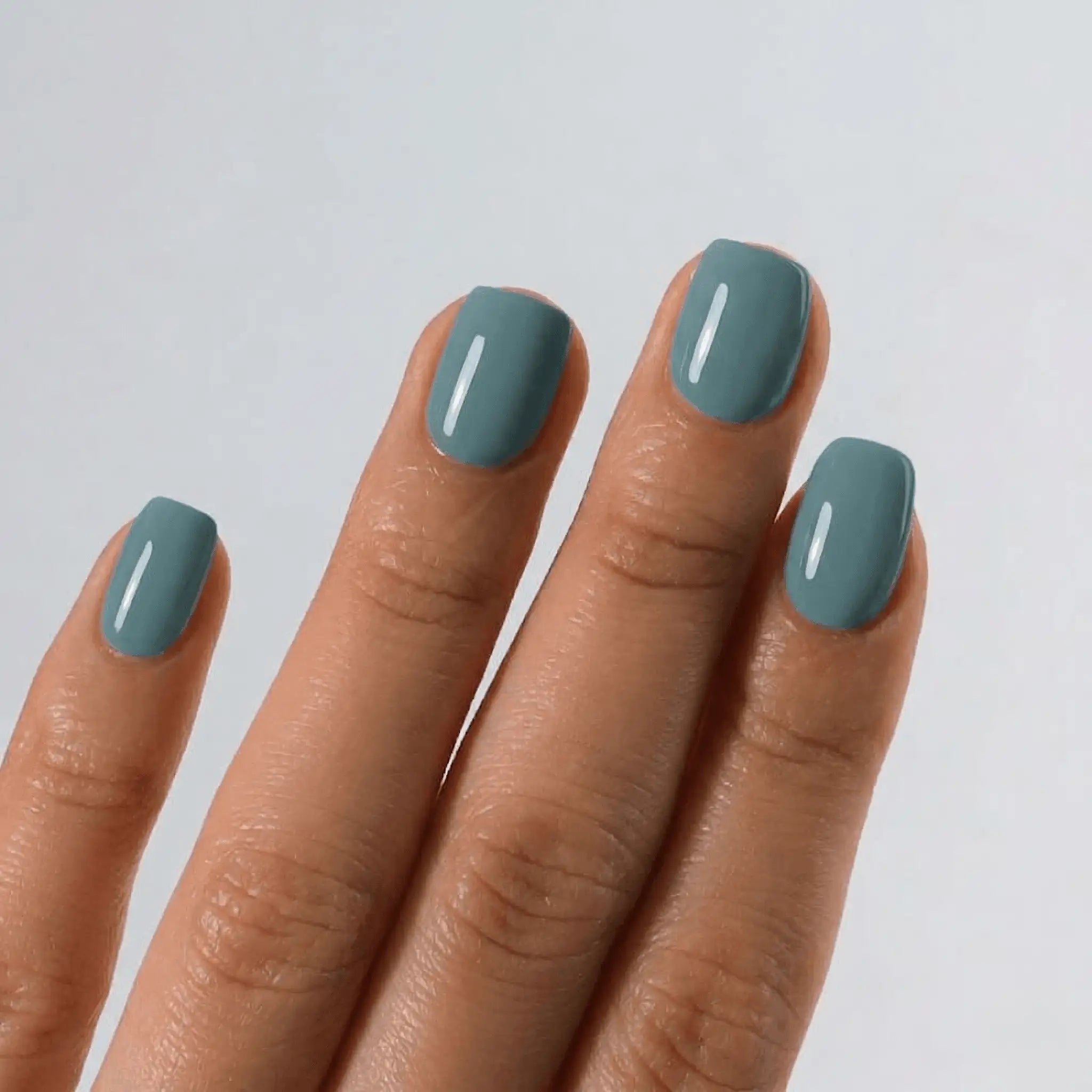 Detailed view of S&L No. 028 Calypso Blue gel polish on square nails with a high-gloss shiny finish.