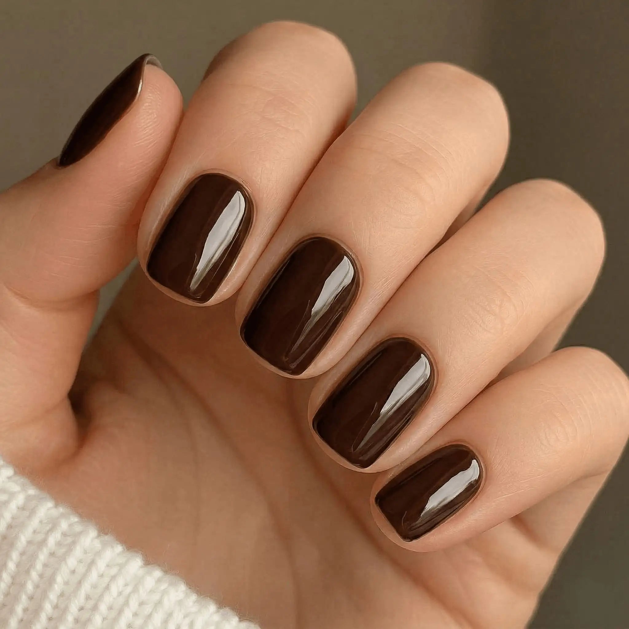 Minimalist lifestyle photography featuring a hand model with square nails in S&L No. 065 Haute Cacao solid brown.