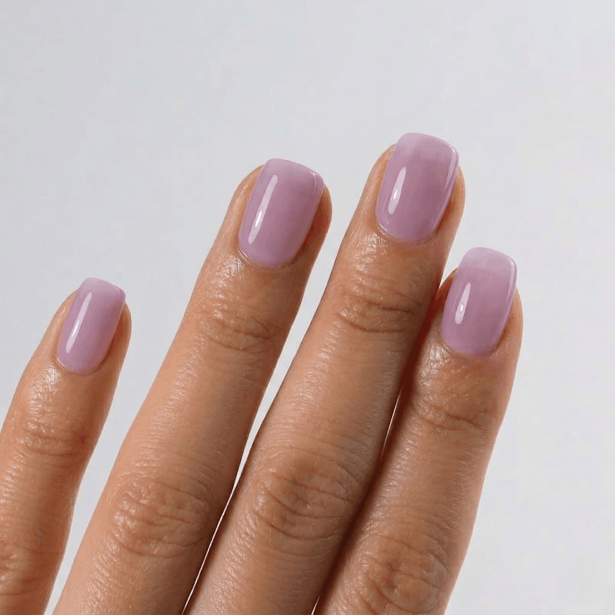 Hand with S&L light purple nail polish - jelly finish on a plain background