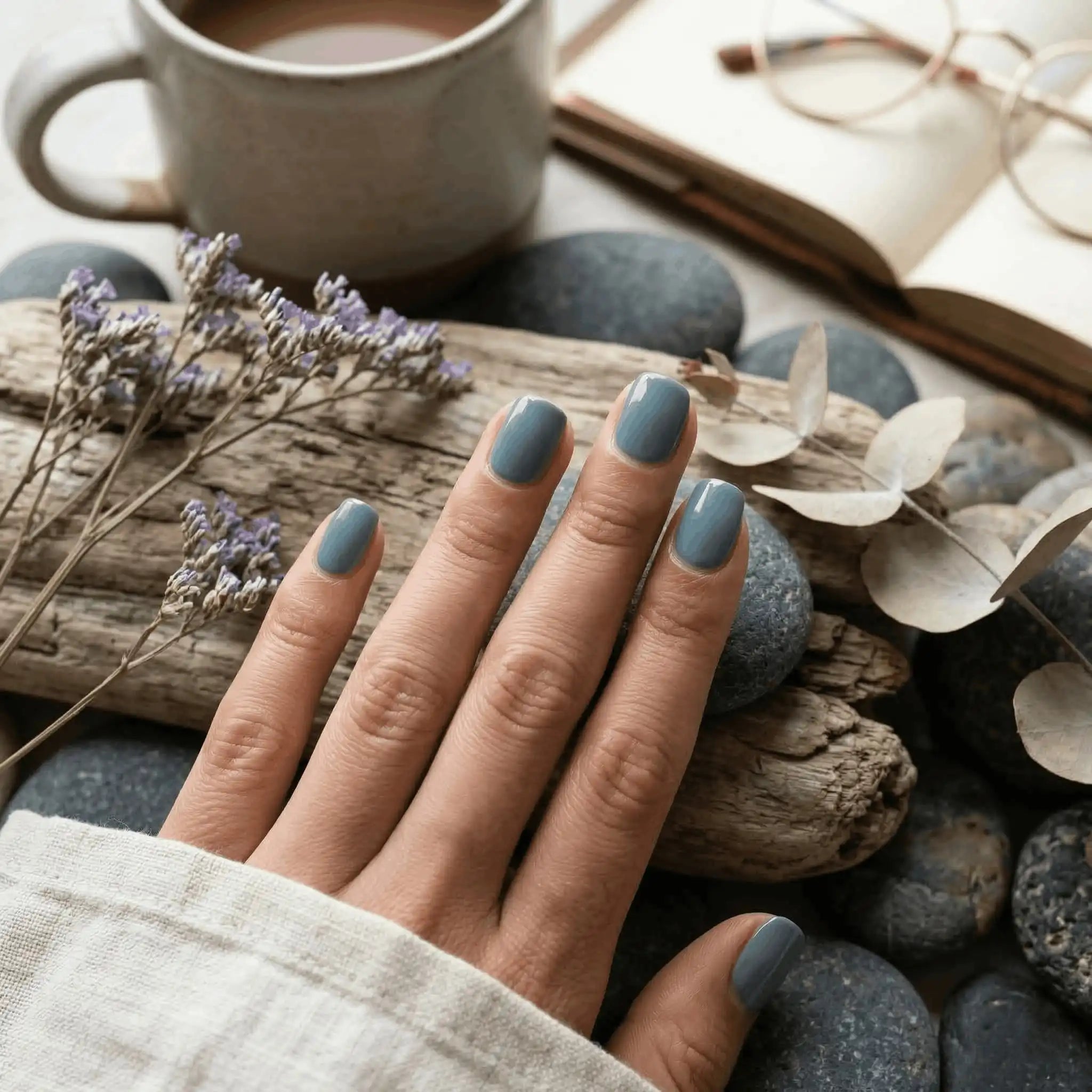 Minimalist lifestyle photography featuring a hand model with square nails in S&L No. 035 Juniper Berry solid blue-grey.