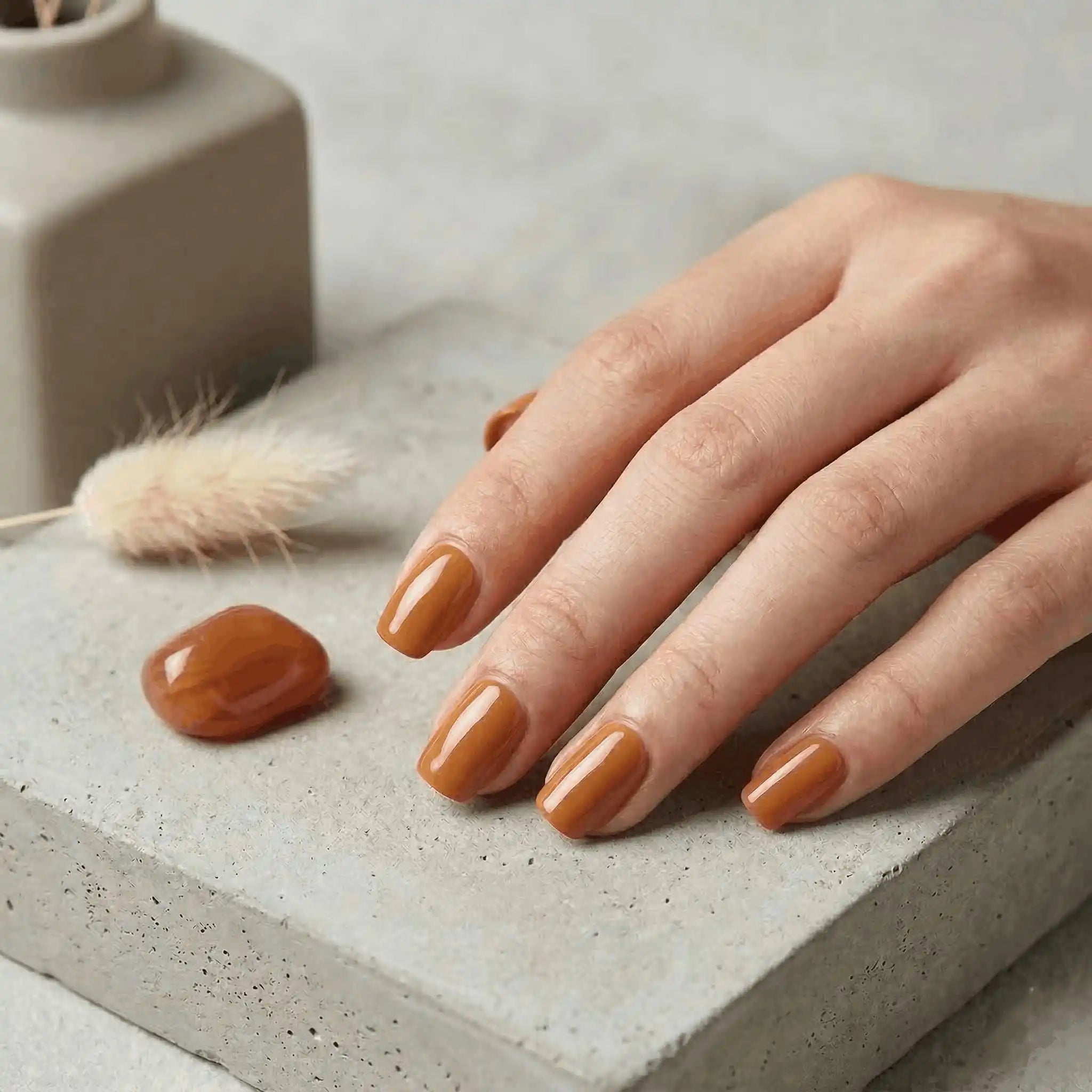 Minimalist lifestyle photography featuring a hand model with square nails in S&L No. 050 Gateaux de Carottes solid orange.