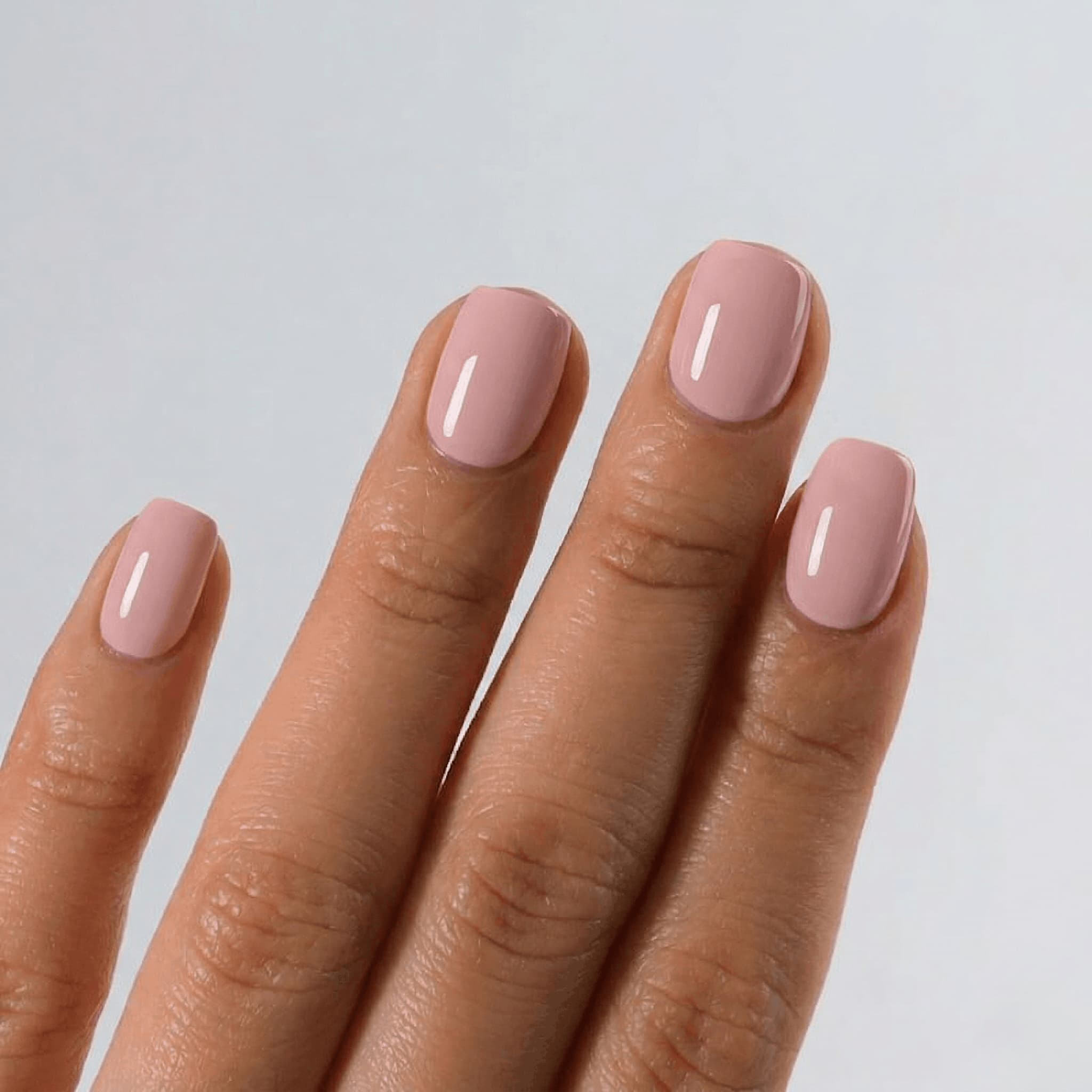 Hand with S&L  pink nail polish on a light gray background
