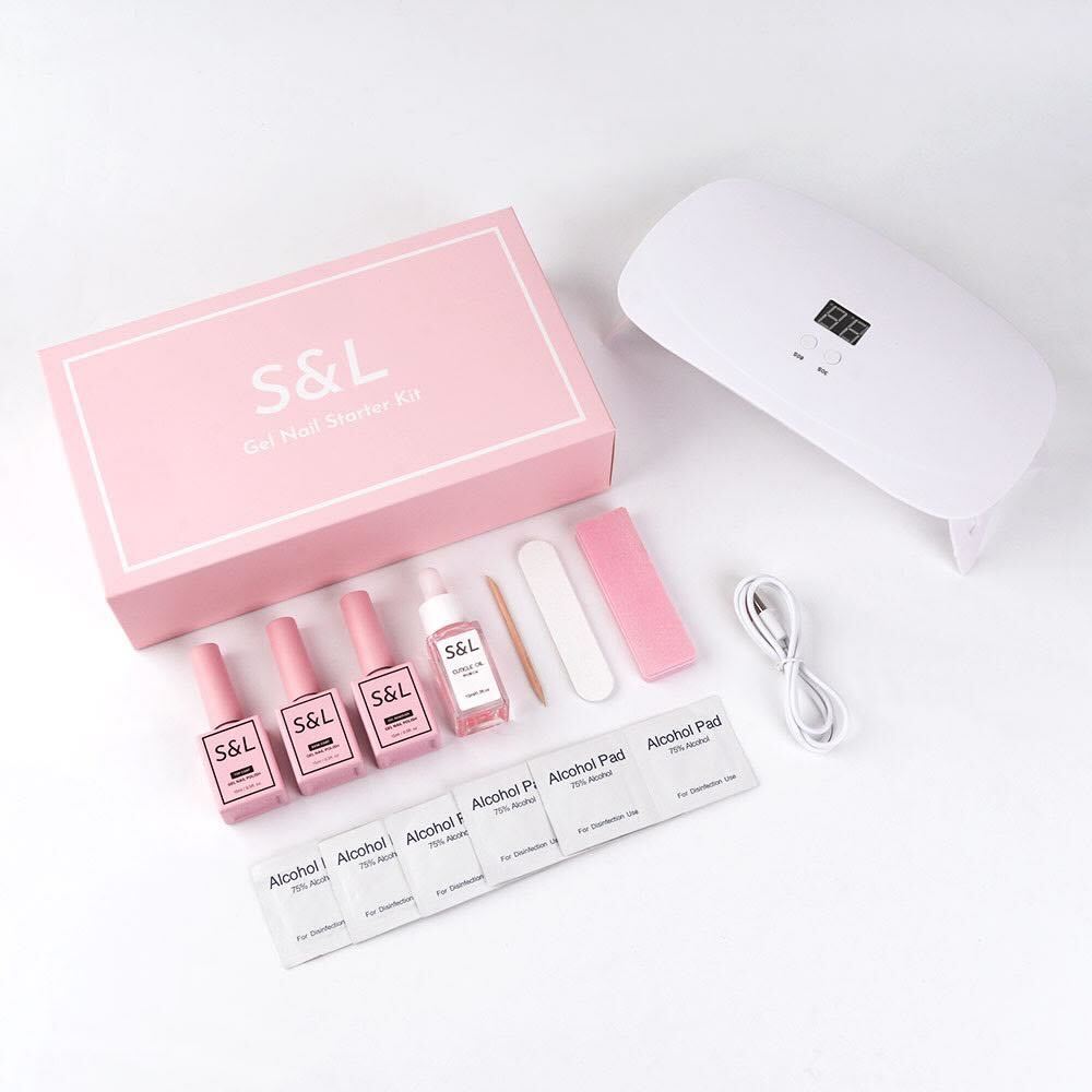 Cosmetic kit with pink bottles, a white device, and accessories on a light gray background