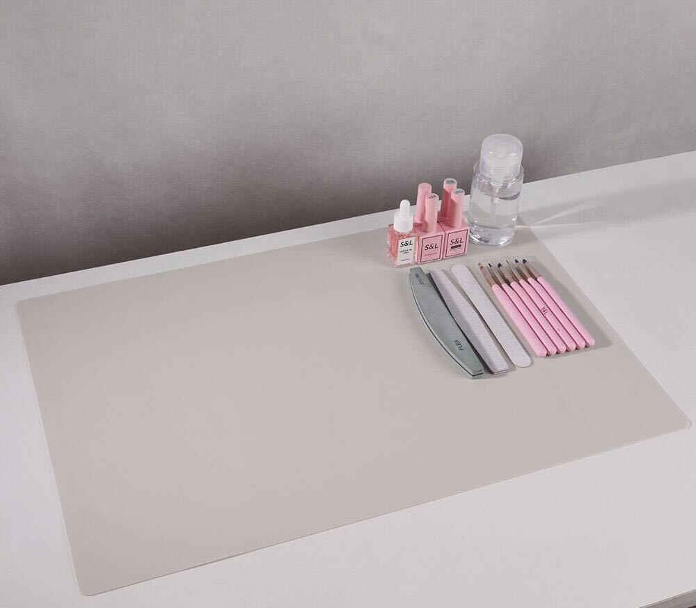 Beige silicone nail mat with S&L nail art tools and products neatly arranged for a manicure setup