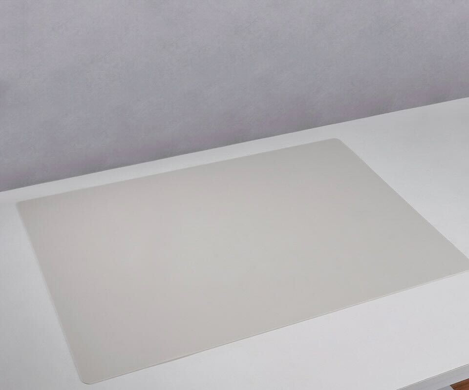 Beige silicone mat on a white table, ideal for nail art and easy clean-up
